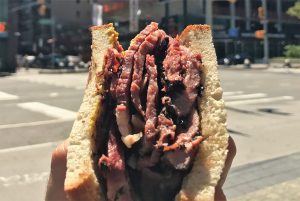 Holding a Katz's Delicatessen pastrami sandwich