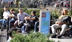 Real New Yorkers eating and talking on a park bench