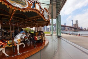 Jane’s Carousel at Brooklyn Bridge Park with the Brooklyn Bridge and Manhattan skyline