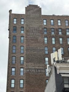Layered ghost signs on Seventh Avenue across from FIT