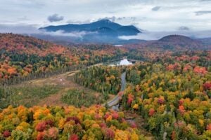 Autumn landscape in Adirondack Park with Little Cherry Patch Pond and Whiteface Mountain in the distance.