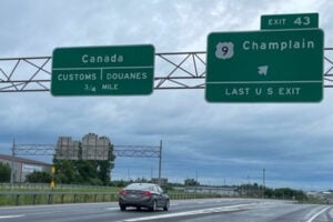Highway signs on Interstate 87 in Champlain, New York, directing motorists to Canadian customs and the last U.S. exit