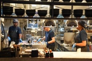 Cooks preparing food in the kitchen of a Midtown Manhattan restaurant in New York City