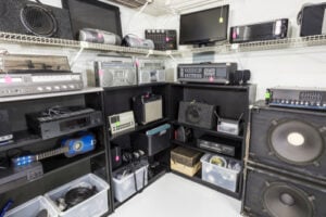 Vintage stereo receivers, speakers, radios, and audio equipment displayed on shelves