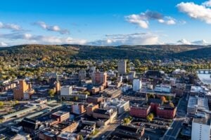 Aerial view of downtown Binghamton, New York, with surrounding hills and the Southern Tier landscape.