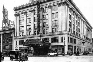 Historic Capitol Theatre on Broadway in New York City in 1920, showing its marquee, vintage automobiles, and surrounding streetscape.