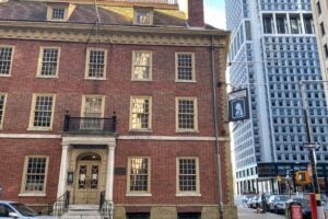 Historic Fraunces Tavern brick building in Manhattan's Financial District surrounded by modern New York City skyscrapers.