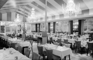 Elegant dining room at Patricia Murphy's Candlelight Restaurant in Yonkers, New York, in 1954, featuring chandeliers and white tablecloths.