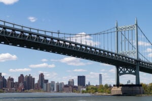 Triborough Bridge spanning the East River between Astoria, Queens, and Wards Island, with the Manhattan skyline in the background.