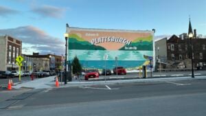Colorful Welcome to Plattsburgh mural depicting Lake Champlain and the Adirondack Mountains on a downtown Plattsburgh building in New York.