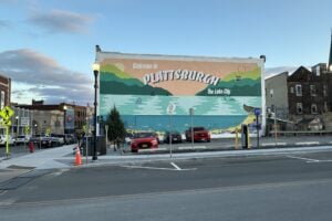 Colorful Welcome to Plattsburgh mural depicting Lake Champlain and the Adirondack Mountains on a downtown Plattsburgh building in New York.